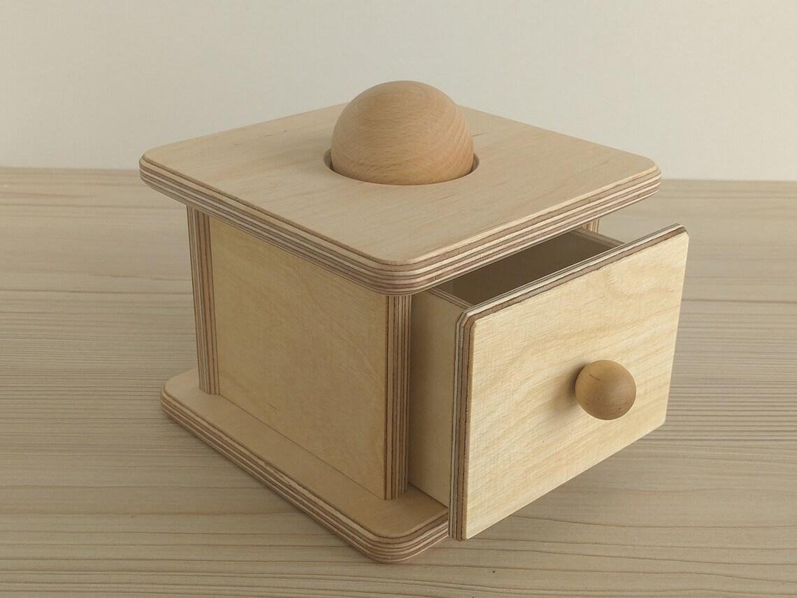 Montessori imbucare kaste ar izvelkamu atvilktni un vienu koka bumbiņu.